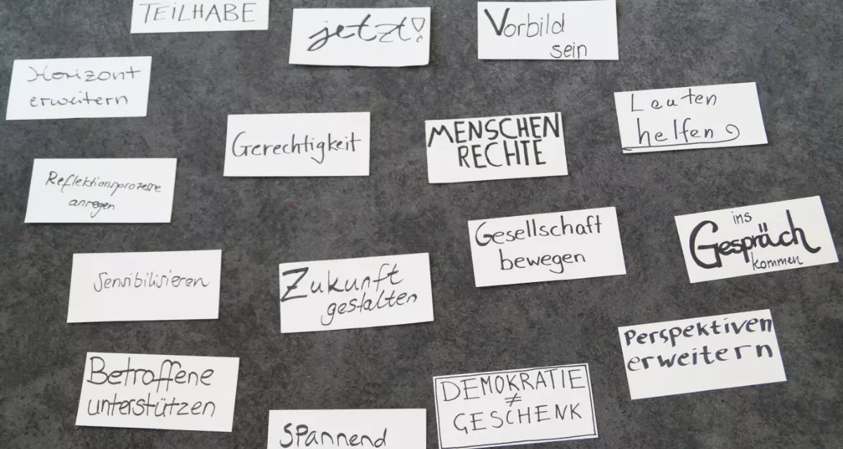 zu den Fortbildungen für Erwachsene. Foto: Begriffe zu Extremismusprävention an Pinnwand. Team meX Begriffe zu Extremismusprävention an Pinnwand. Foto: Team meX